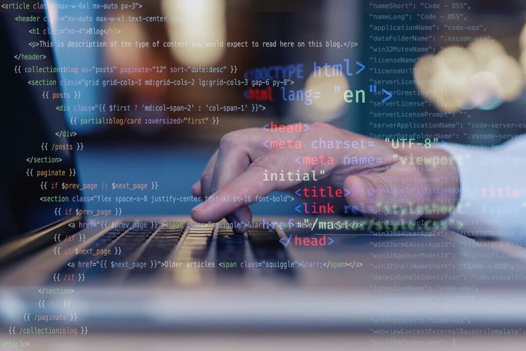 A man works at a laptop, program code is in the foreground