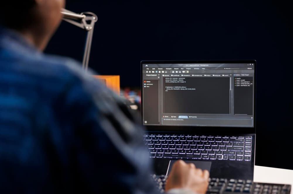 Over-the-shoulder view of person coding on a laptop