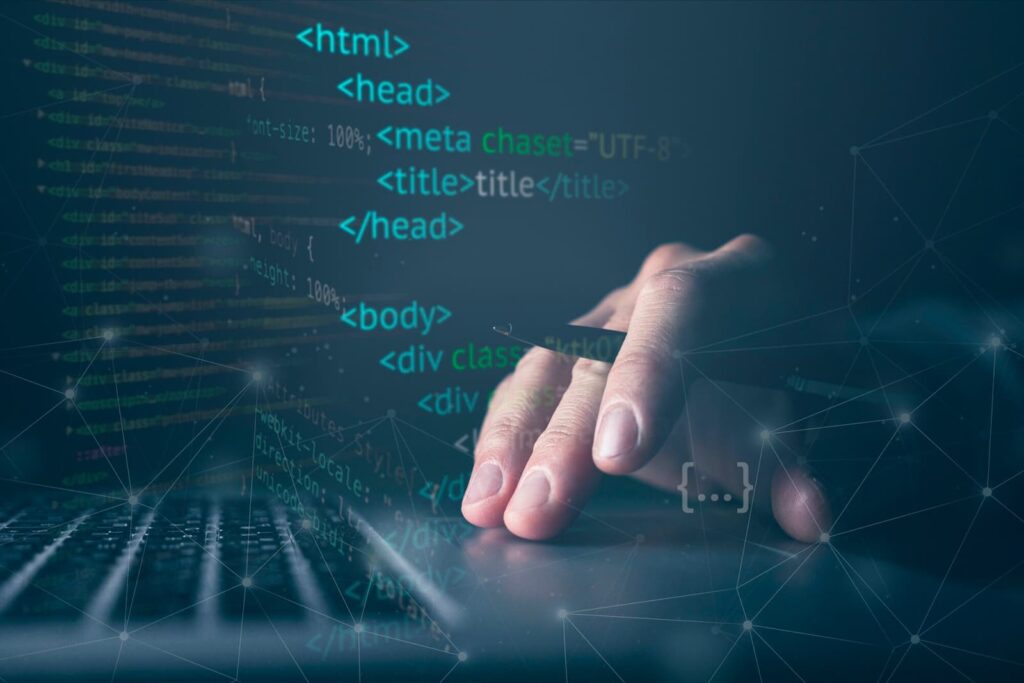 Hand on laptop keyboard with program code